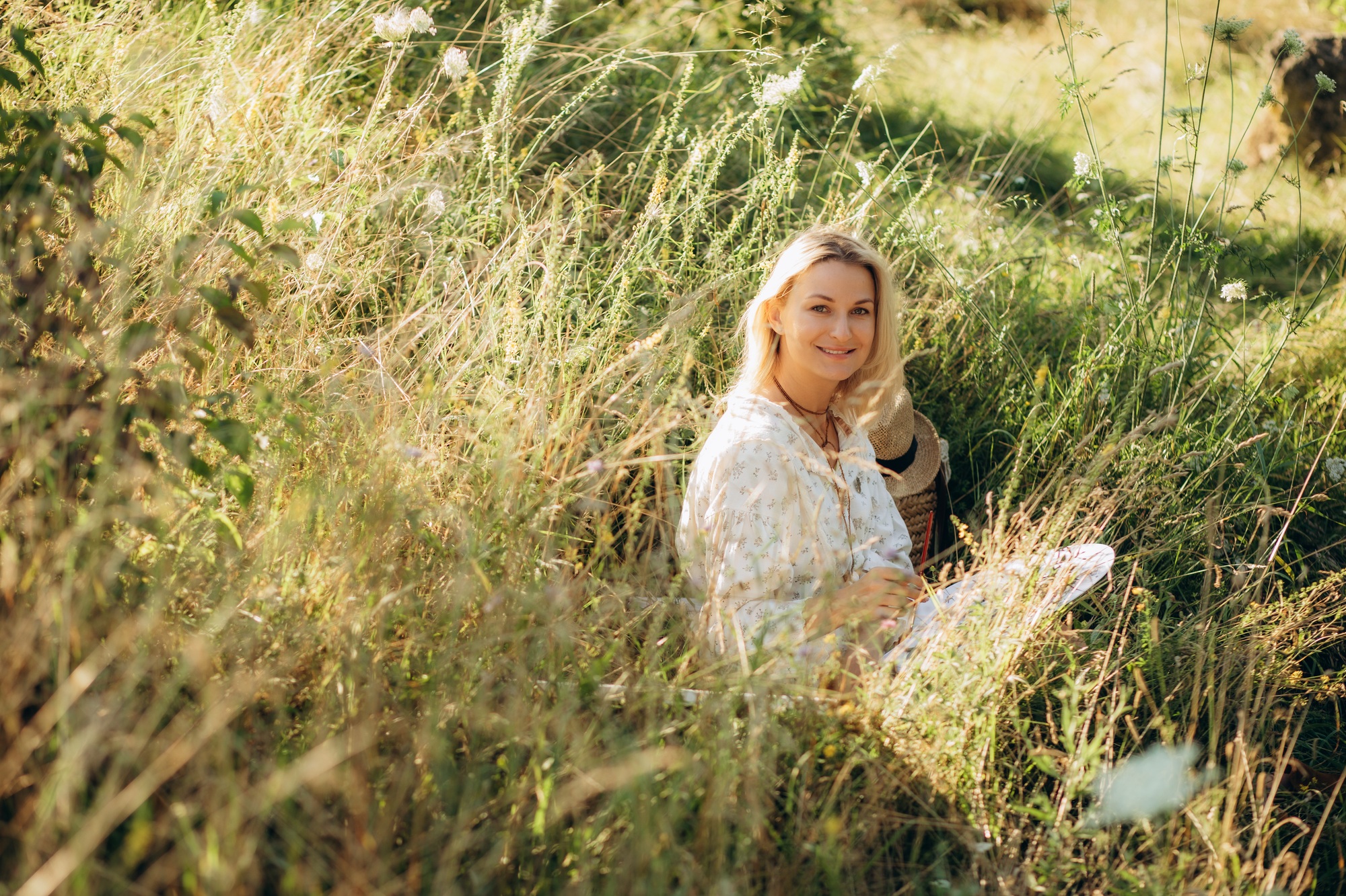 a woman artist paints a picture in nature.